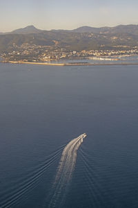 High angle view of sea by city against sky