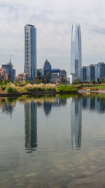 Reflection of buildings in city against sky