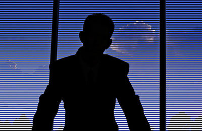 Silhouette man standing against window