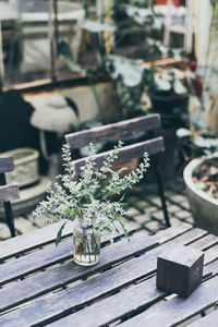 High angle view of flower vase by wooden block on table in restaurant