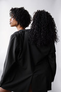 Two beautiful dark skin women wearing same jacket