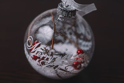 Close-up of christmas decoration on glass against black background