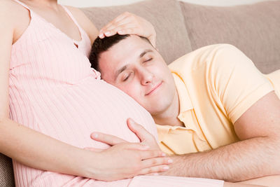 Midsection of couple lying on bed