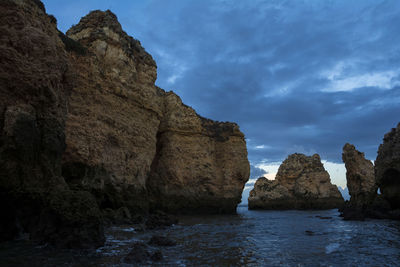 Rock formations by sea against sky