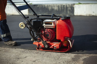 Low section of man riding push scooter on street