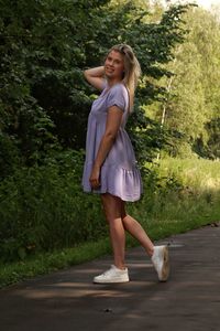 Young woman smiling while standing on footpath