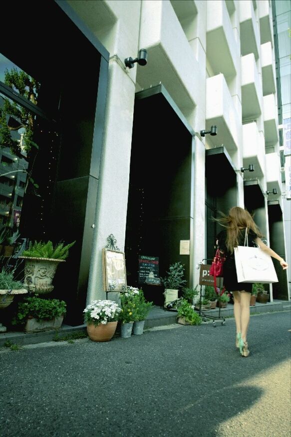 REAR VIEW OF WOMAN WALKING ON BUILT STRUCTURE