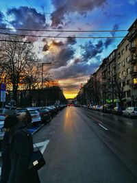 Cars on road against sky in city