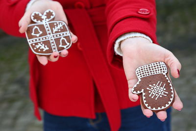 Midsection of woman holding gingerbread cookies during christmas