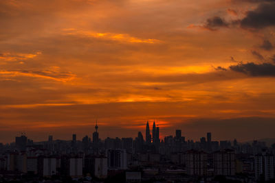 View of cityscape against cloudy sky during sunset