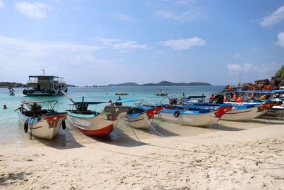 Boats moored on beach against sky