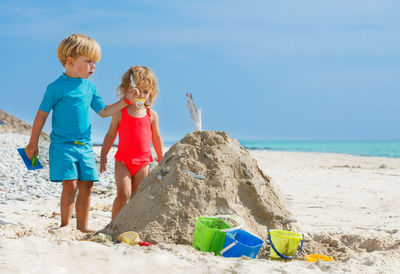 Rear view of boy sitting on beach