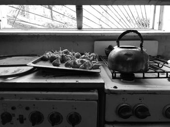 Kettle on stove by garlics on kitchen counter