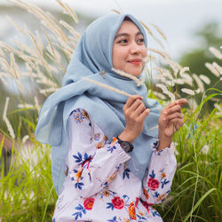 Portrait of smiling young woman lying on field