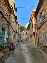 Narrow alley amidst buildings in town. old town pollença, mallorca, spain.