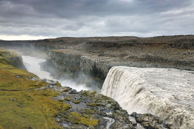 Scenic view of waterfall against sky