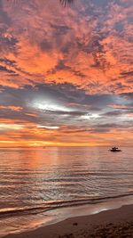 Scenic view of sea against dramatic sky during sunset