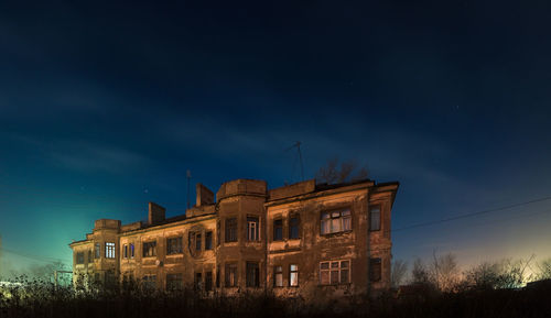 Low angle view of old spooky building against sky at night