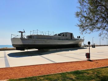 Man standing on boat against clear blue sky