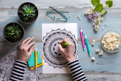 Cropped hands of woman drawing on paper