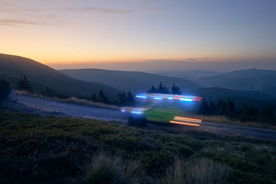 Light trails of ambulance car of emergency medical service on mountain road at night. 