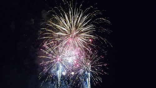 Low angle view of firework display at night