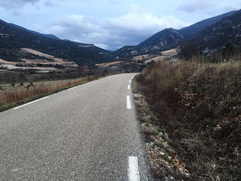 Surface level of empty road against mountain range