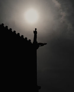 Low angle view of silhouette statue against sky