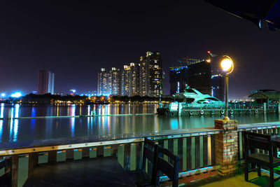 Restaurant by saigon river with illuminated city buildings seen in background