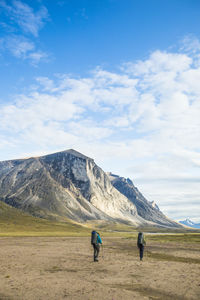 Backpackers hiking through akshayak pass, baffin island, canada.