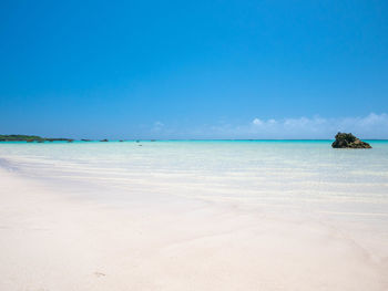 Scenic view of beach against blue sky