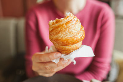 Close-up of woman holding pink cake