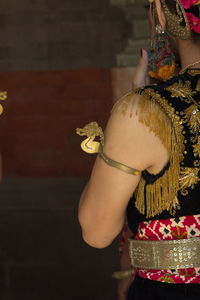 Midsection of woman standing against wall