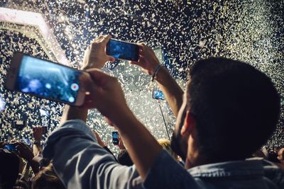 People photographing with mobile phones at concert