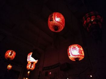 Low angle view of illuminated lanterns hanging at night