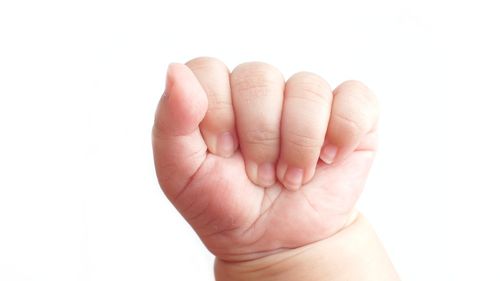 Close-up of hand holding hands over white background