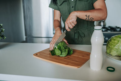 Midsection of man preparing food on cutting board