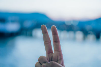 Cropped hand gesturing at beach