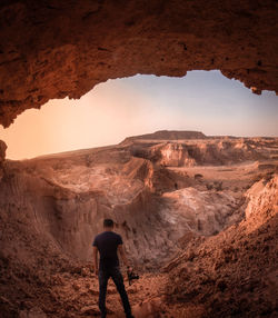 Rear view of man standing on rock