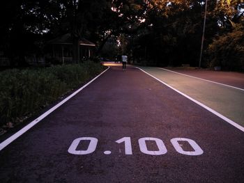 Text on road against trees