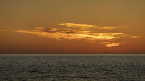 Scenic view of sea against orange sky