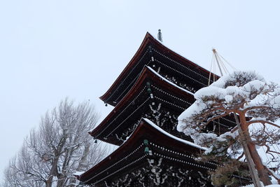 Low angle view of traditional building against sky during winter