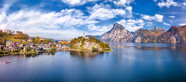 Panoramic shot of buildings by mountains against sky