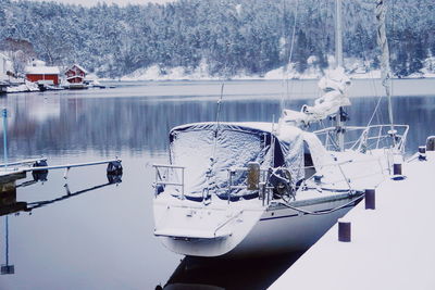 Boats moored on lake against sky