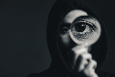 Close-up portrait of human eye against black background