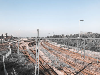 Train in railroad tracks against clear sky during winter