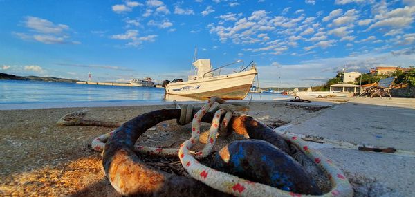 Boats moored on beach by sea against sky