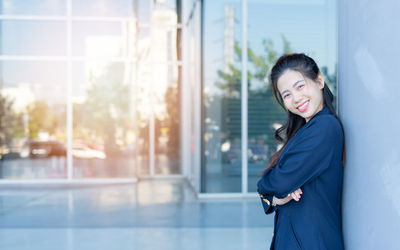 Side view of a smiling young woman standing outdoors