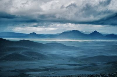 Scenic view of mountains against cloudy sky