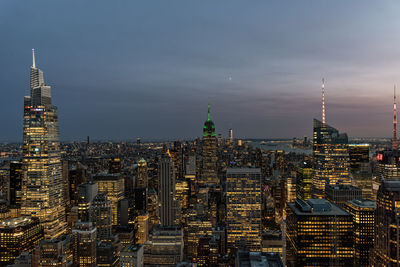 Illuminated cityscape against sky at night